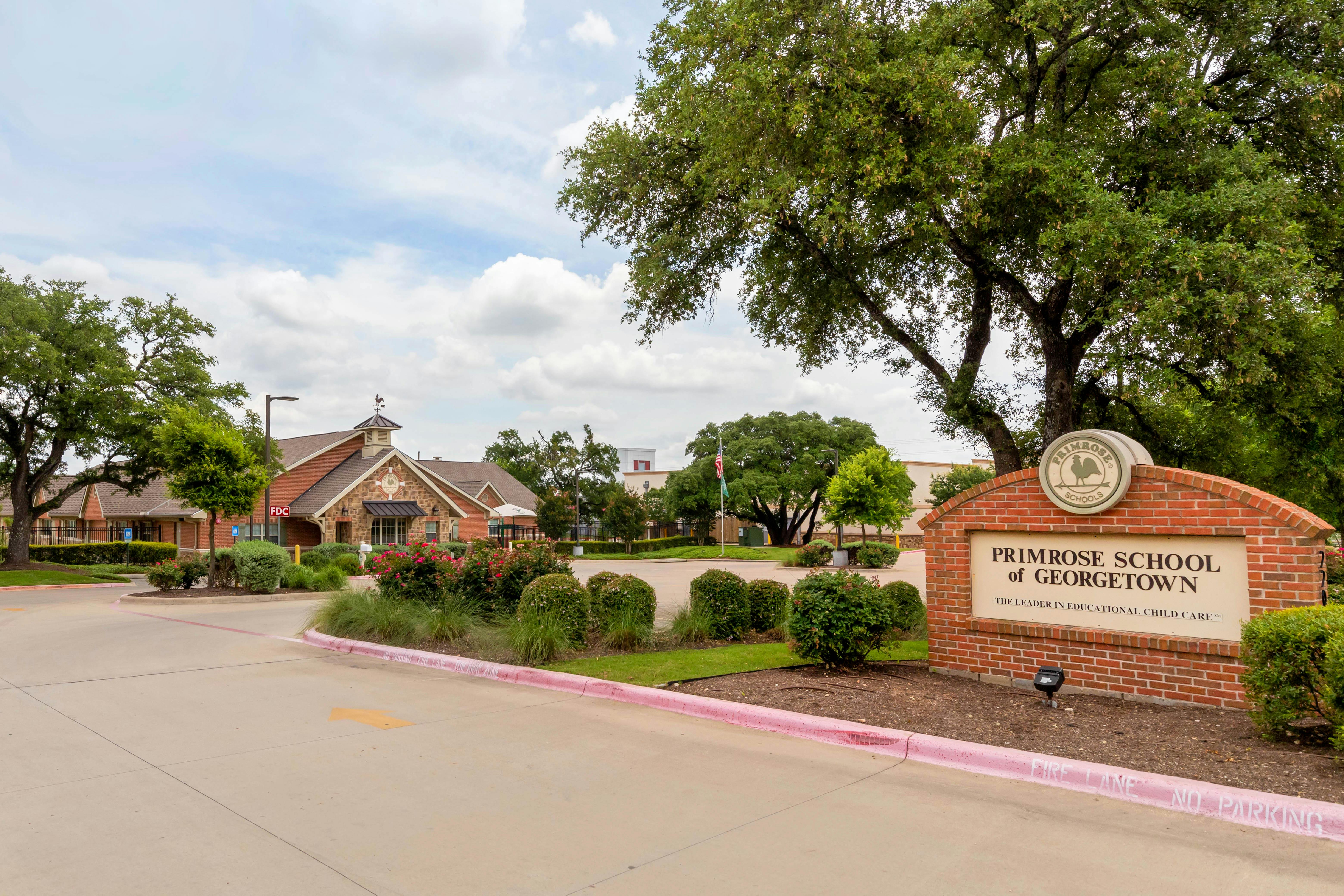 Primrose School of Georgetown sign and building exterior with trees and driveway
