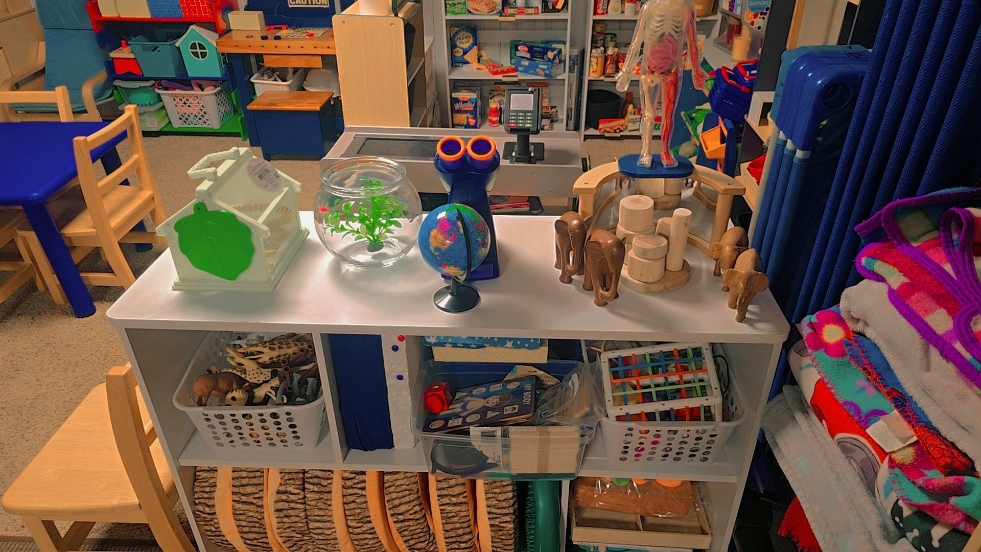 Shelf with various educational toys and items in a classroom setting