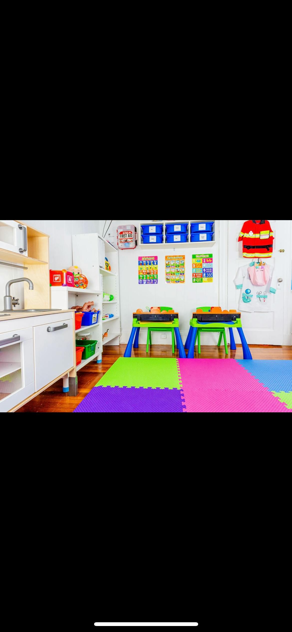 Play kitchen and two activity tables on a colorful foam mat