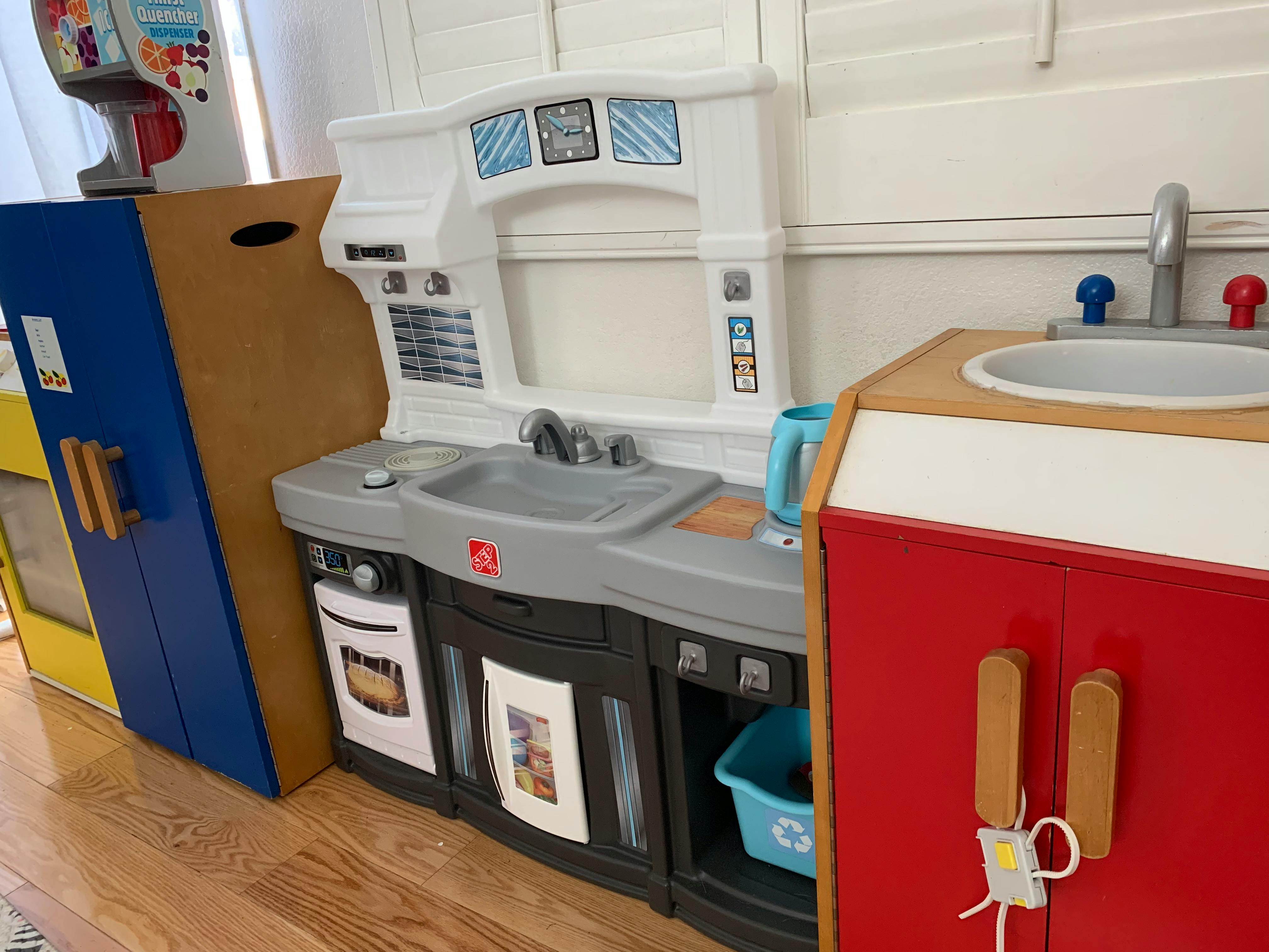 Children's play kitchen with sink, stove, and refrigerator