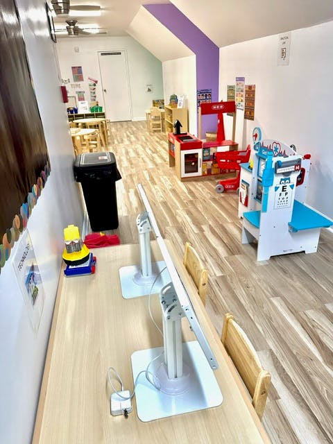 Playroom with toy kitchen, eye doctor station, and computer monitors
