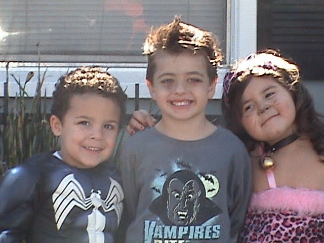 Three children in costumes posing together