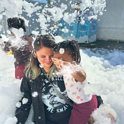 Person and child playing in foam