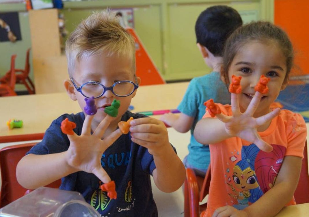 Two children with colorful playdough on their fingers
