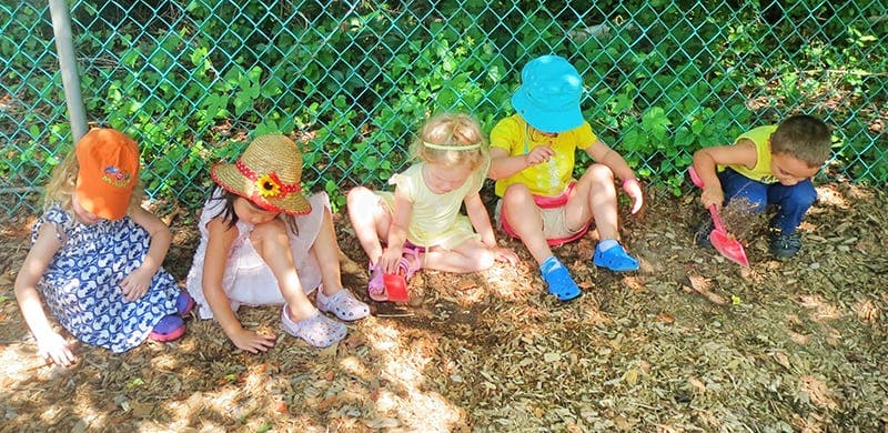 Children sitting on the ground playing with toys