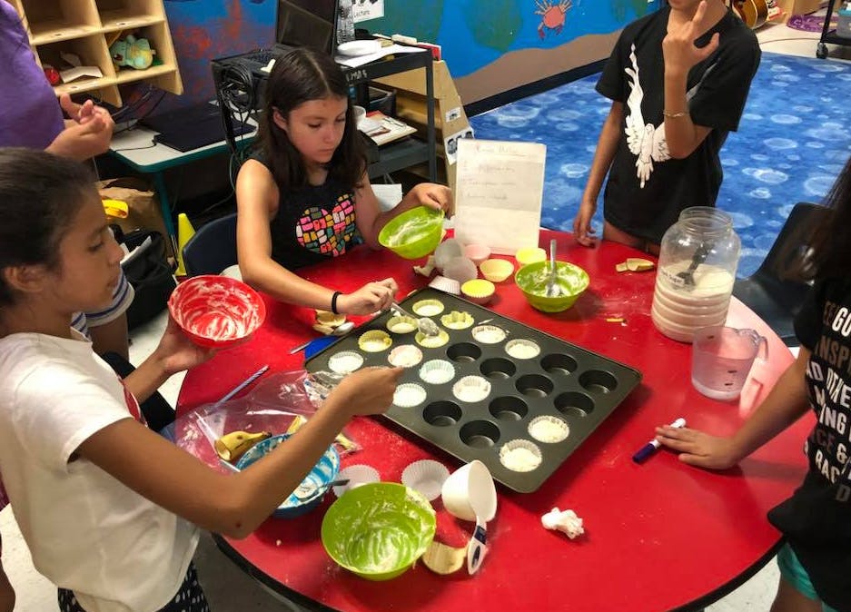 Children making cupcakes in a classroom