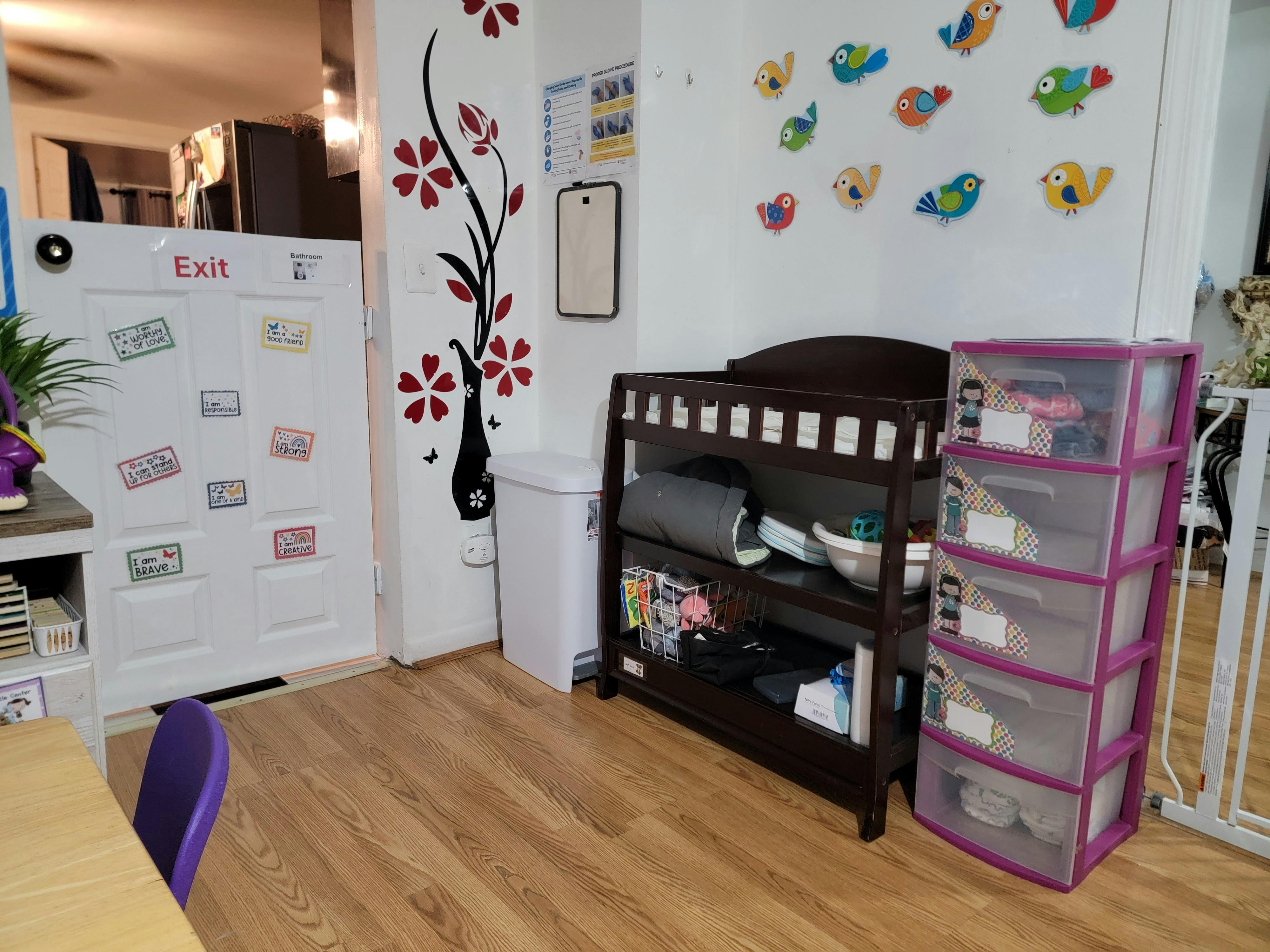 Changing table with storage next to a door with an exit sign
