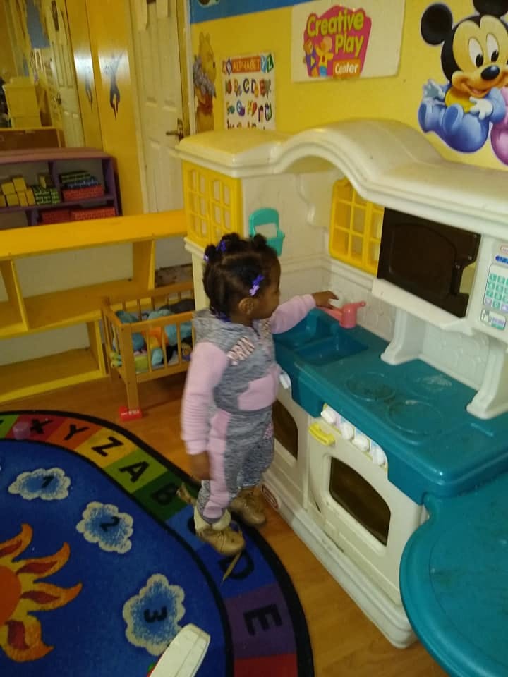 Child playing with a toy kitchen set in a classroom
