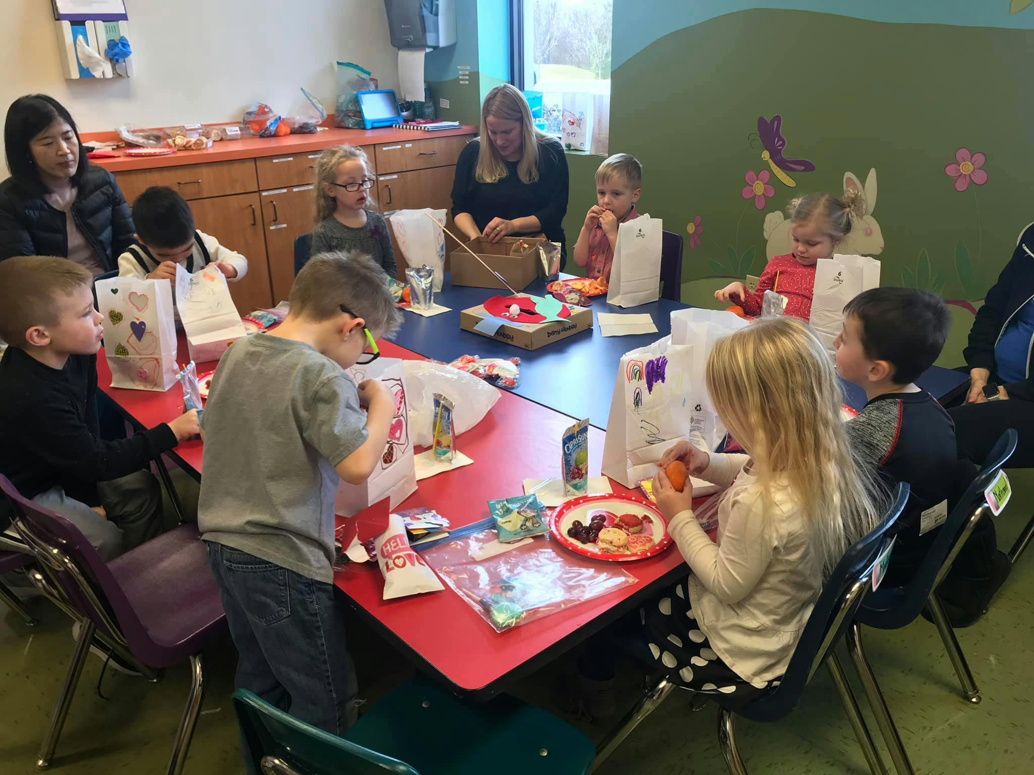 Adults and children sitting around a table with craft supplies