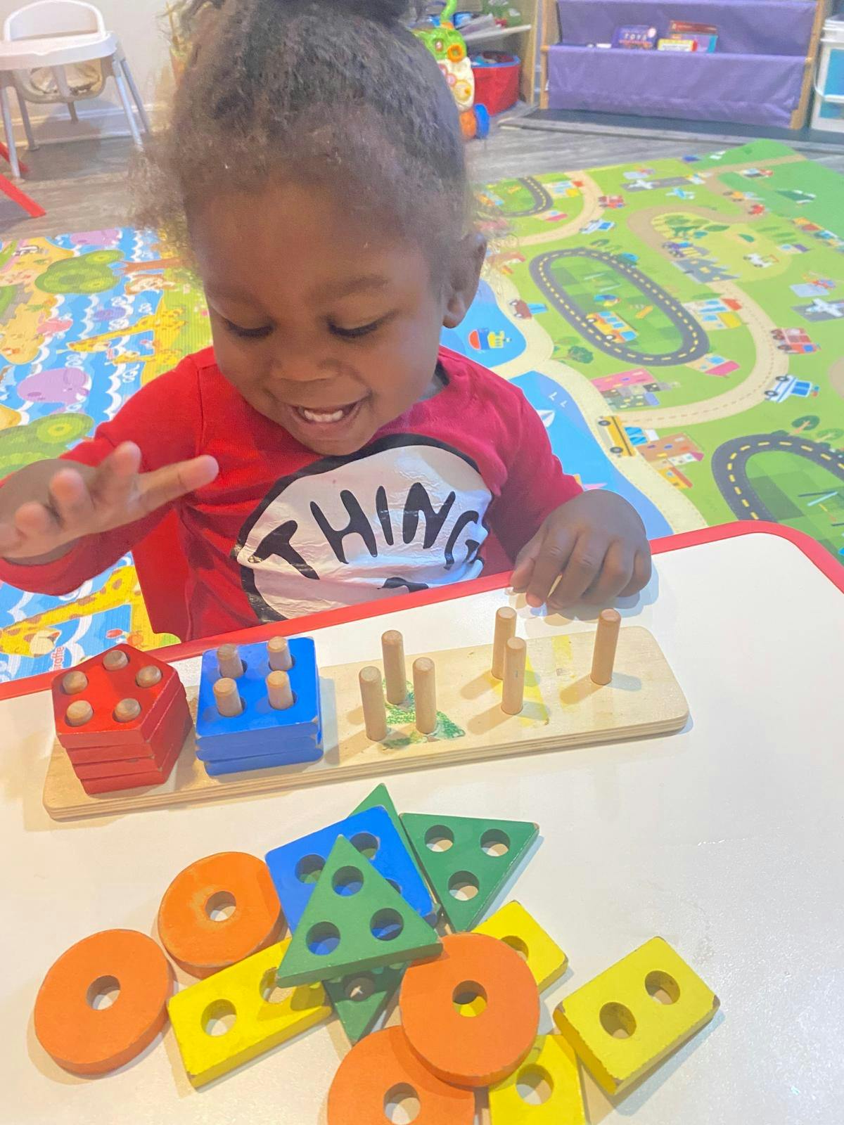 Child playing with wooden shape sorter toy