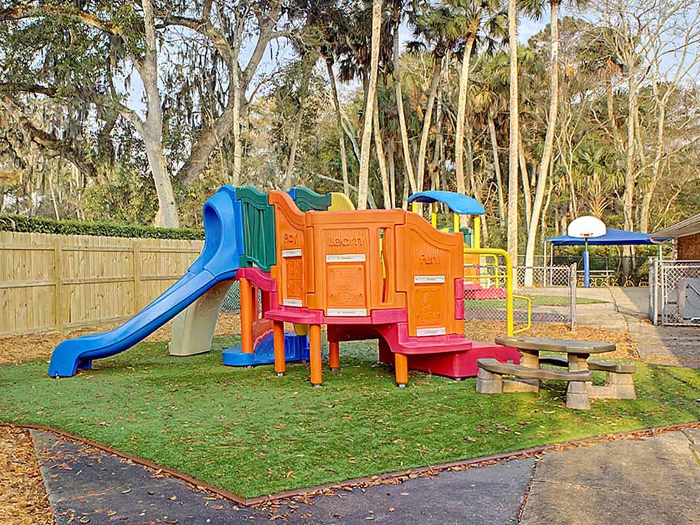 Colorful playground structure with a blue slide on artificial grass