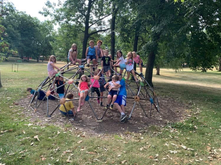 Children playing on a geodesic dome climber in a park