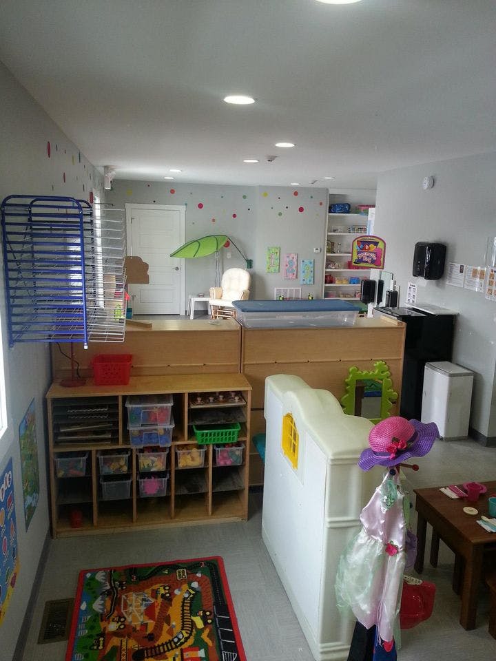 A classroom with cubbies, a play mat, and various children's items