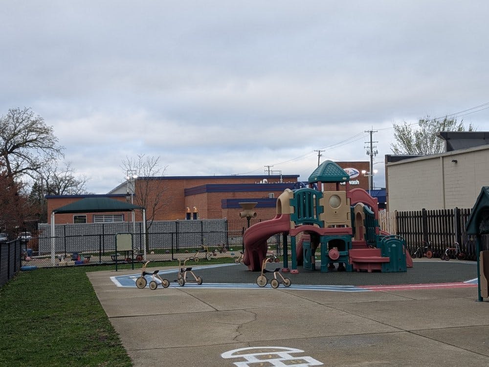 Empty playground with colorful play equipment and small tricycles on the ground