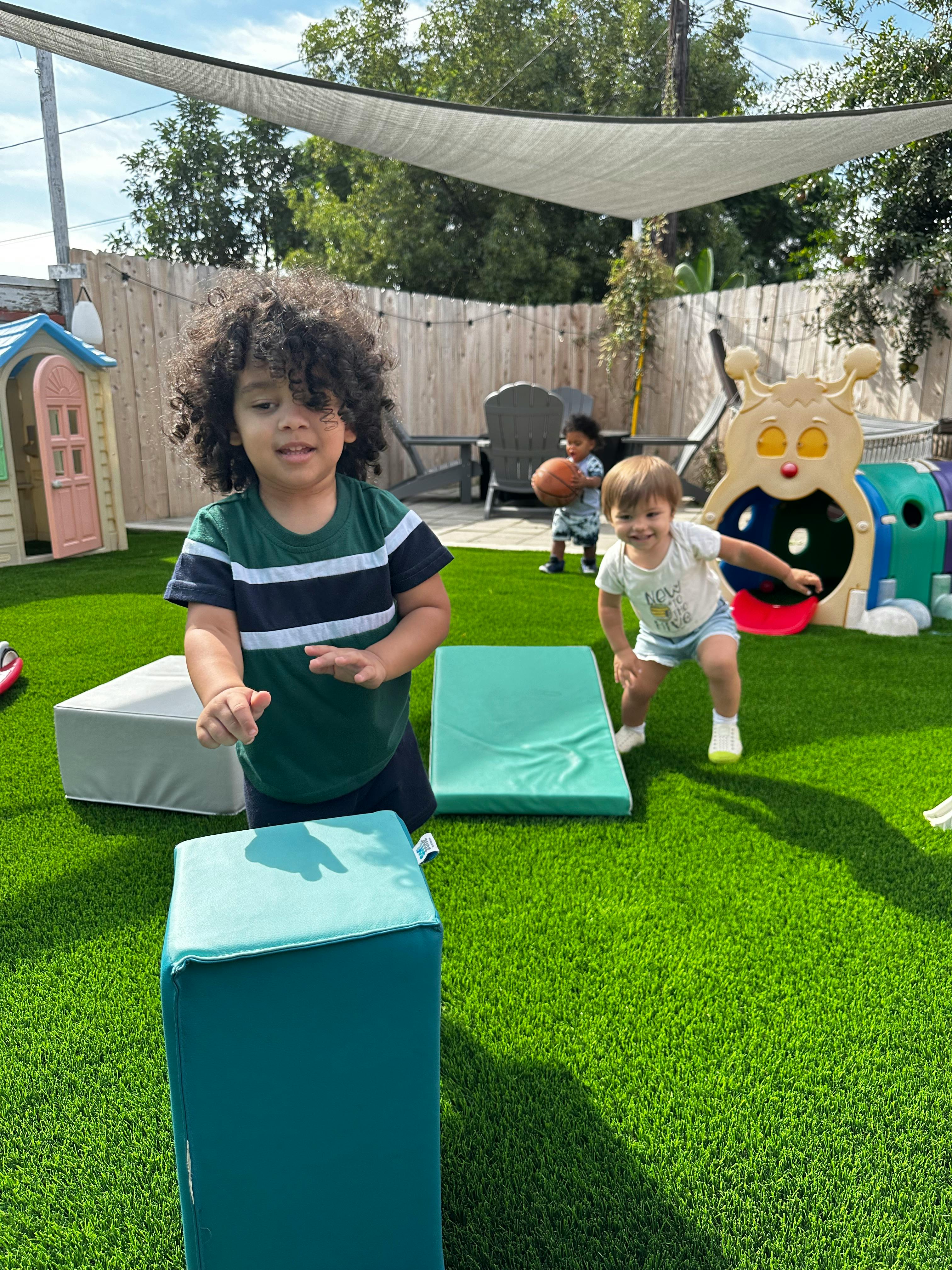 Children playing on artificial grass with soft play blocks