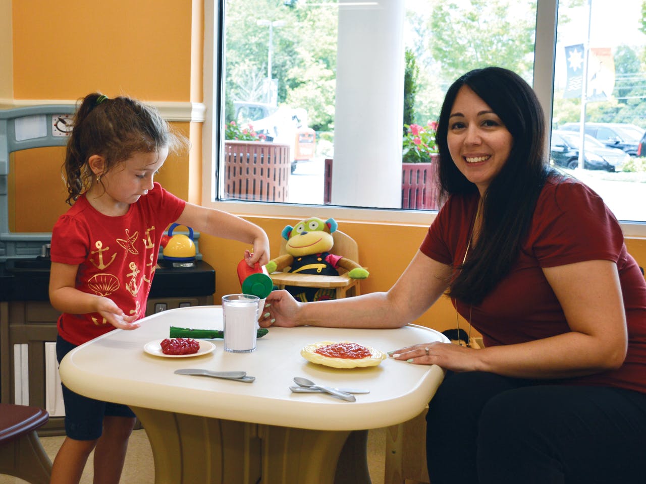 Adult and child at a table with plates of food