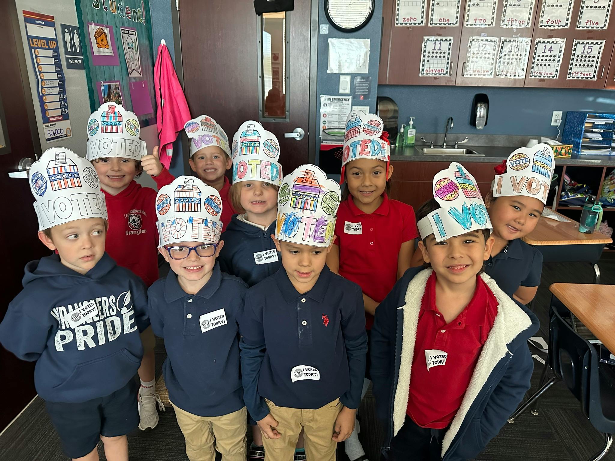 Group of children wearing paper hats in a classroom