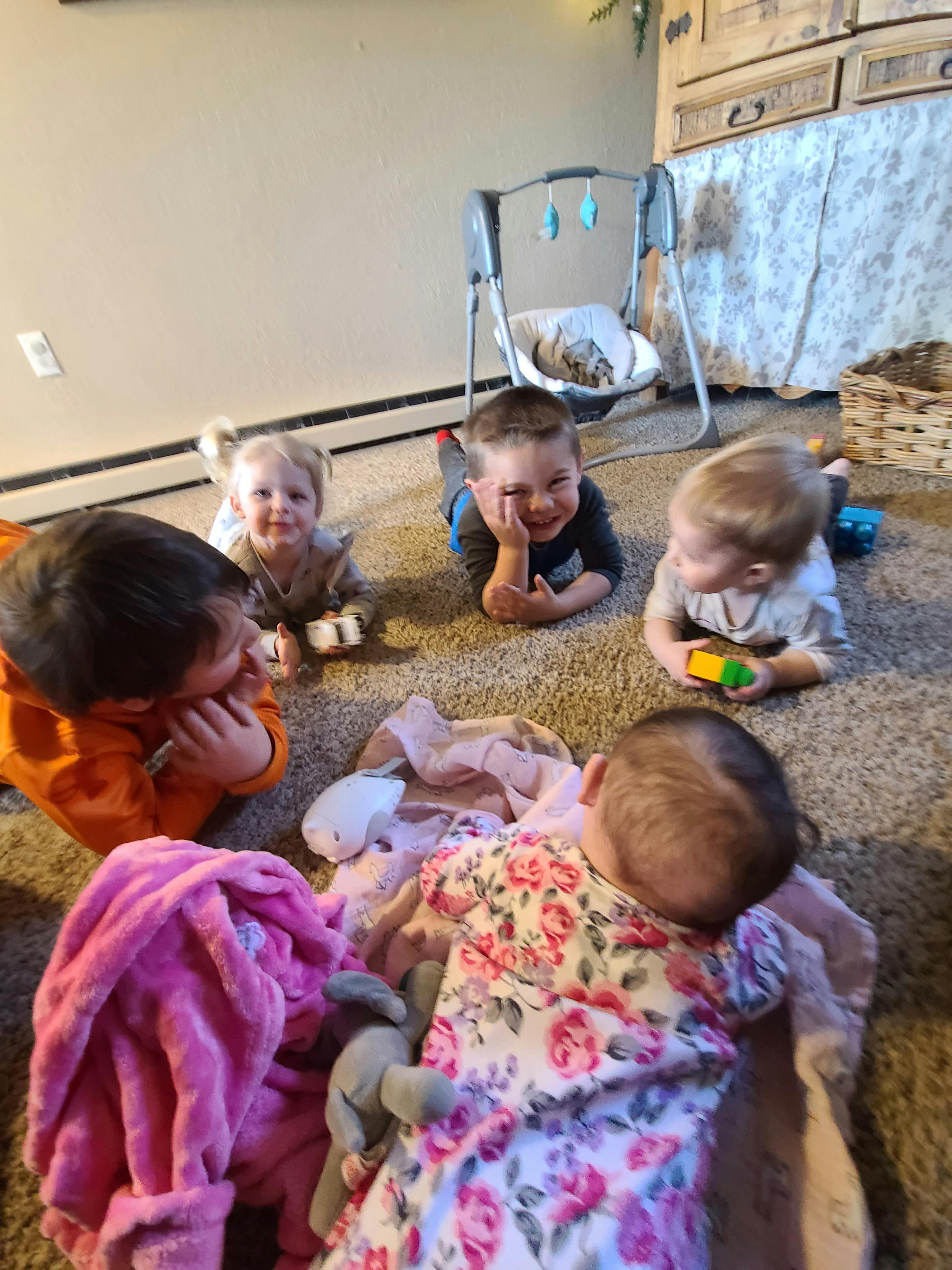 Four children and one baby on the floor