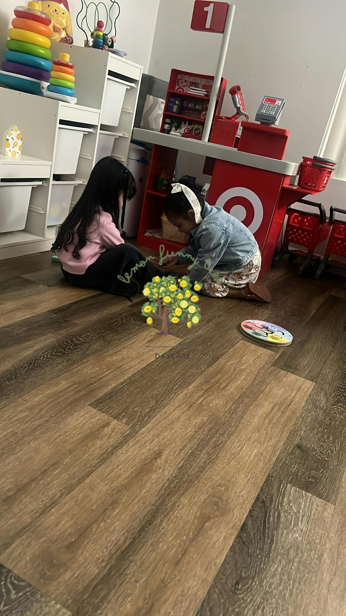 Two children playing on the floor in a room with toy shelves