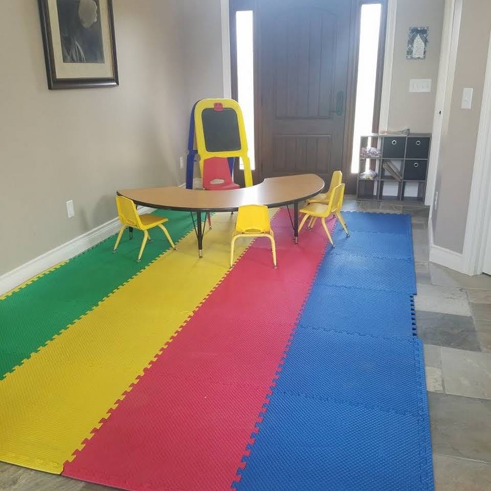 Children's table and chairs on a colorful foam mat