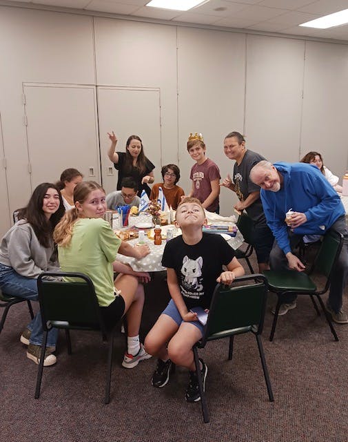 Group of people and children gathered around a table