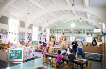 Adults and children in a large classroom