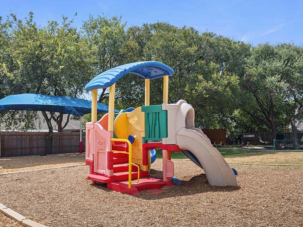Colorful playground structure with a slide on wood chips