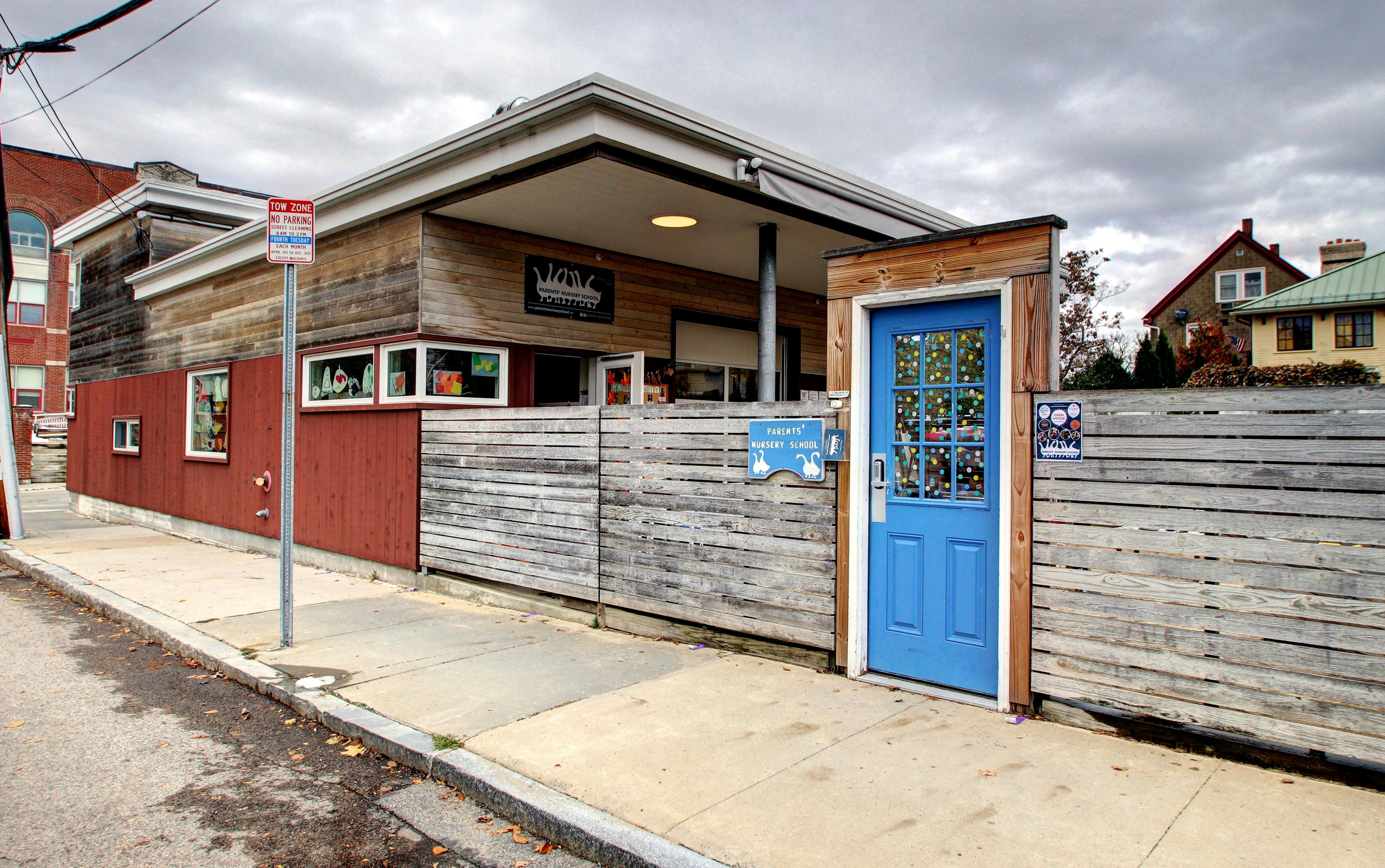 Building with a blue door and wooden fence