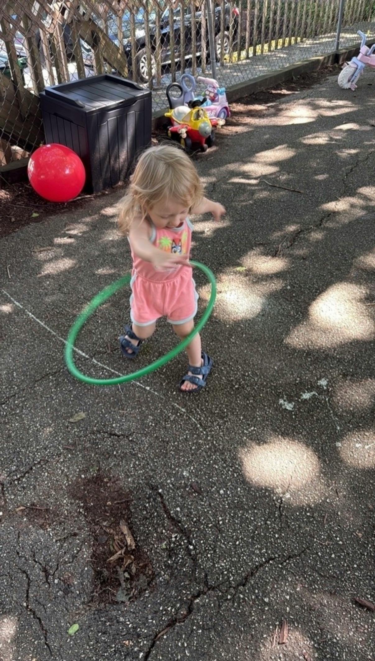 Child playing with a hula hoop outdoors