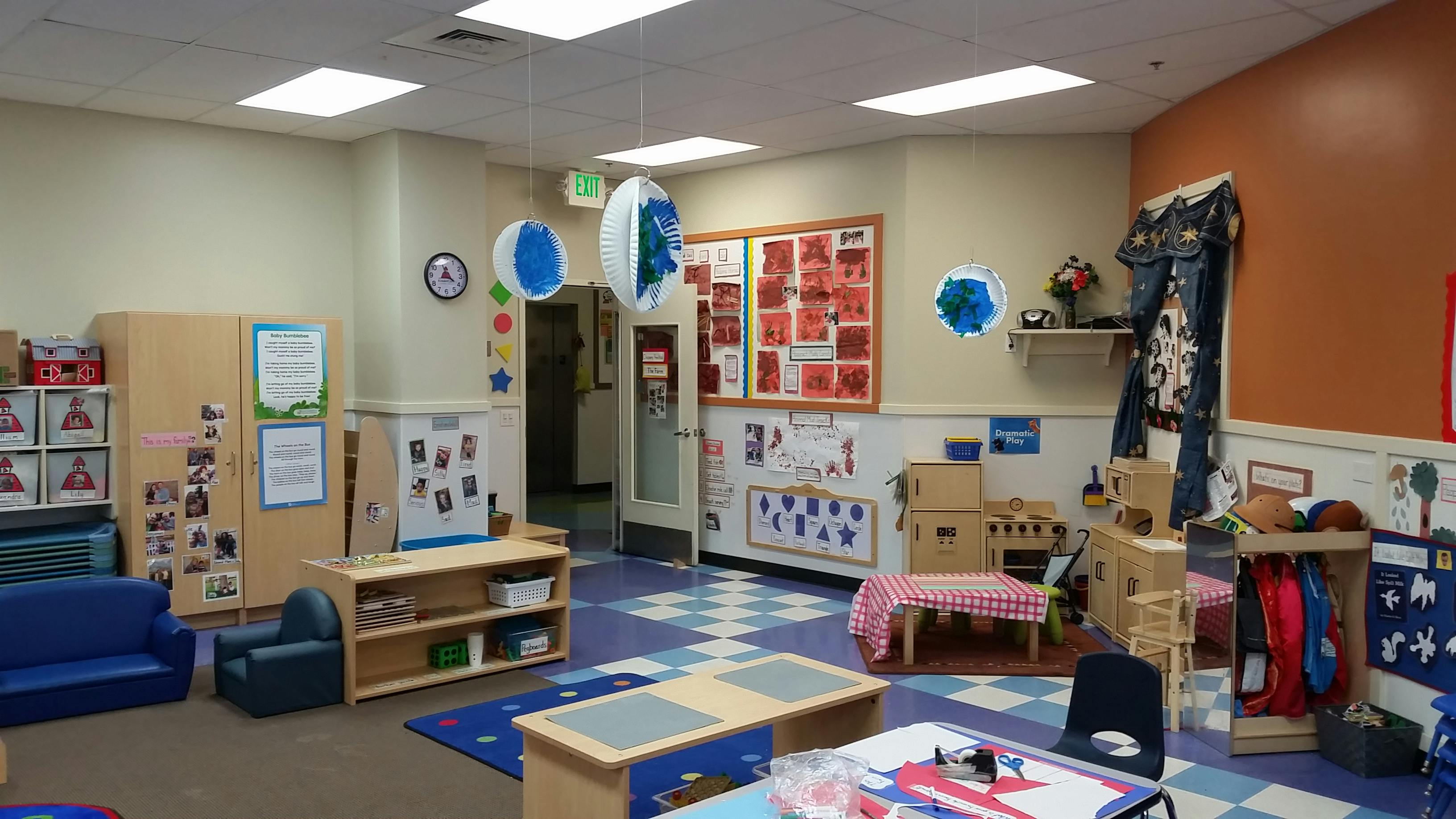 Classroom with cubbies, small tables and chairs, and a play kitchen area