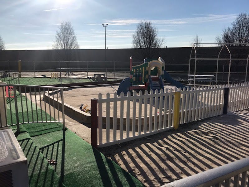 Outdoor playground with a white picket fence