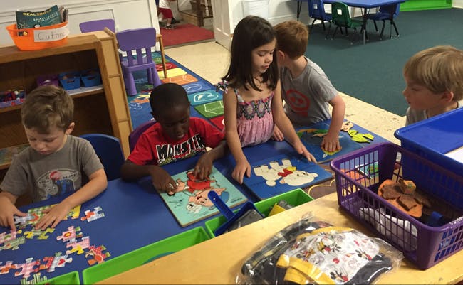 Children playing with puzzles and toys at tables