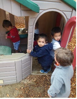 Children playing in and around a playhouse