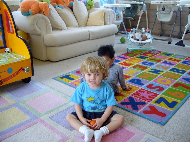Two children on a colorful alphabet rug