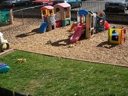 Playground with multiple colorful play structures and wood chips