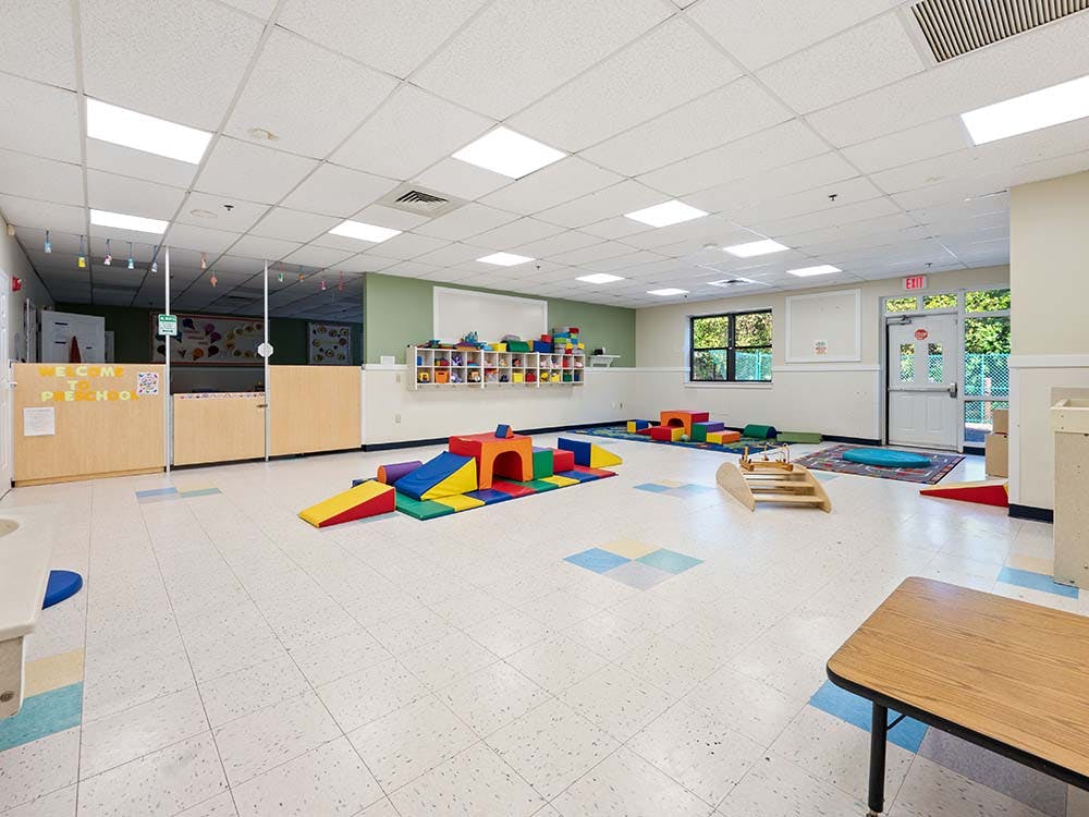 Playroom with soft colorful play equipment and child-height furniture