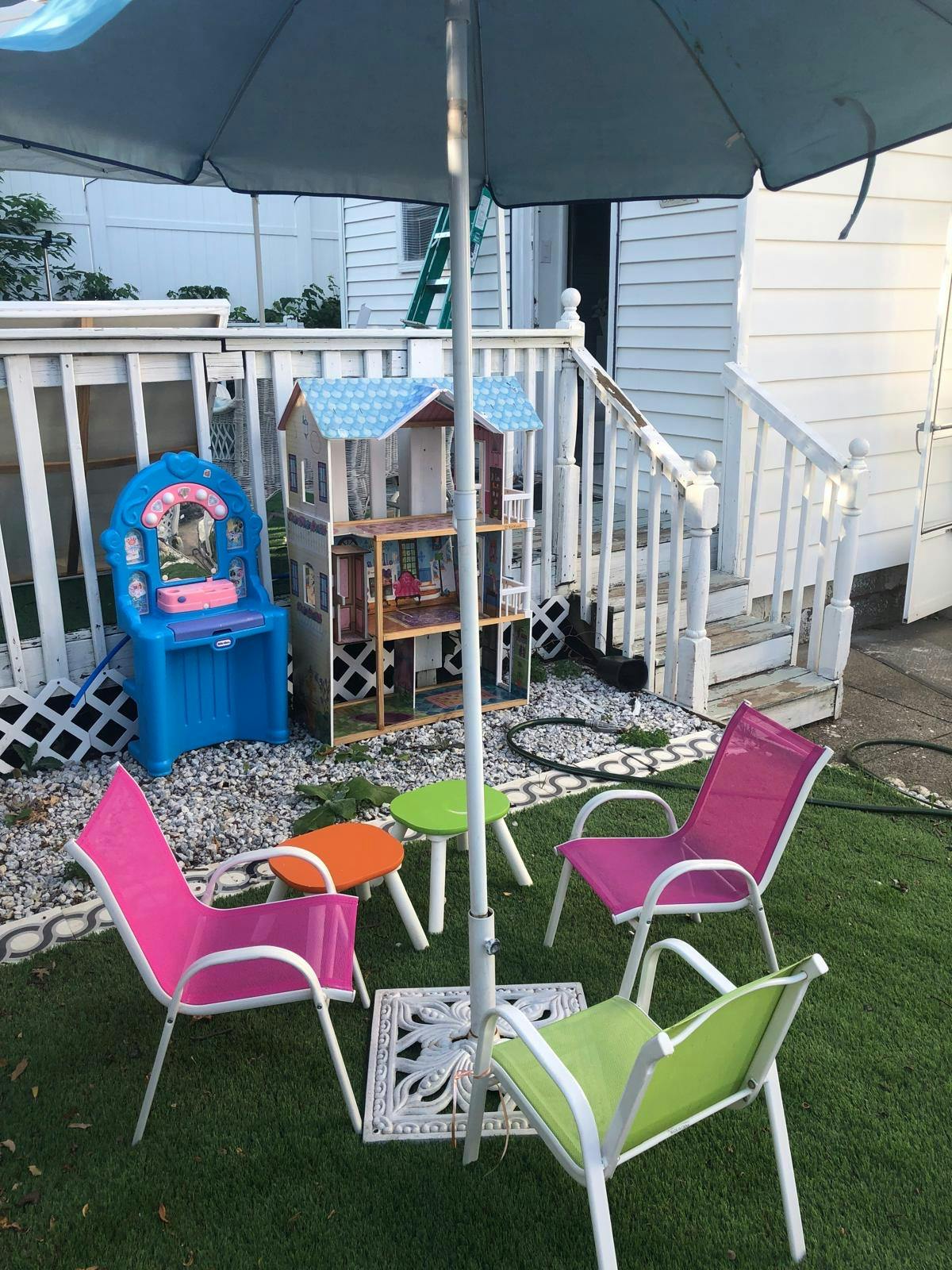 Patio umbrella over colorful chairs and tables on grass