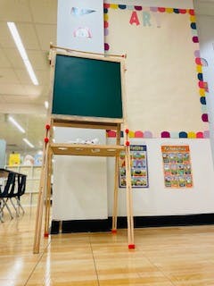 Easel with a green chalkboard in a classroom
