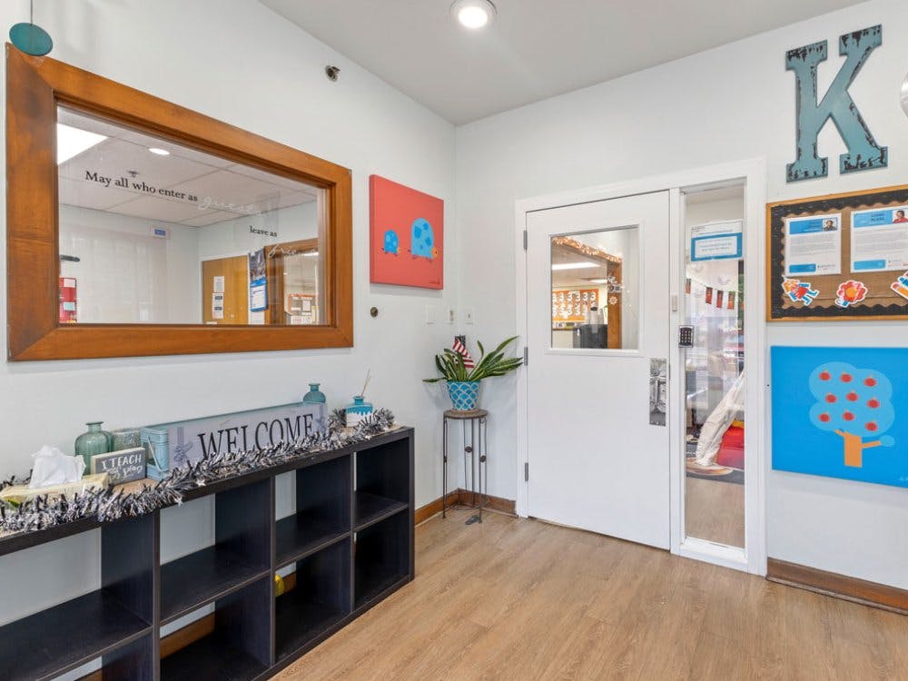 Classroom entryway with a mirror, welcome sign, and a large letter K on the wall