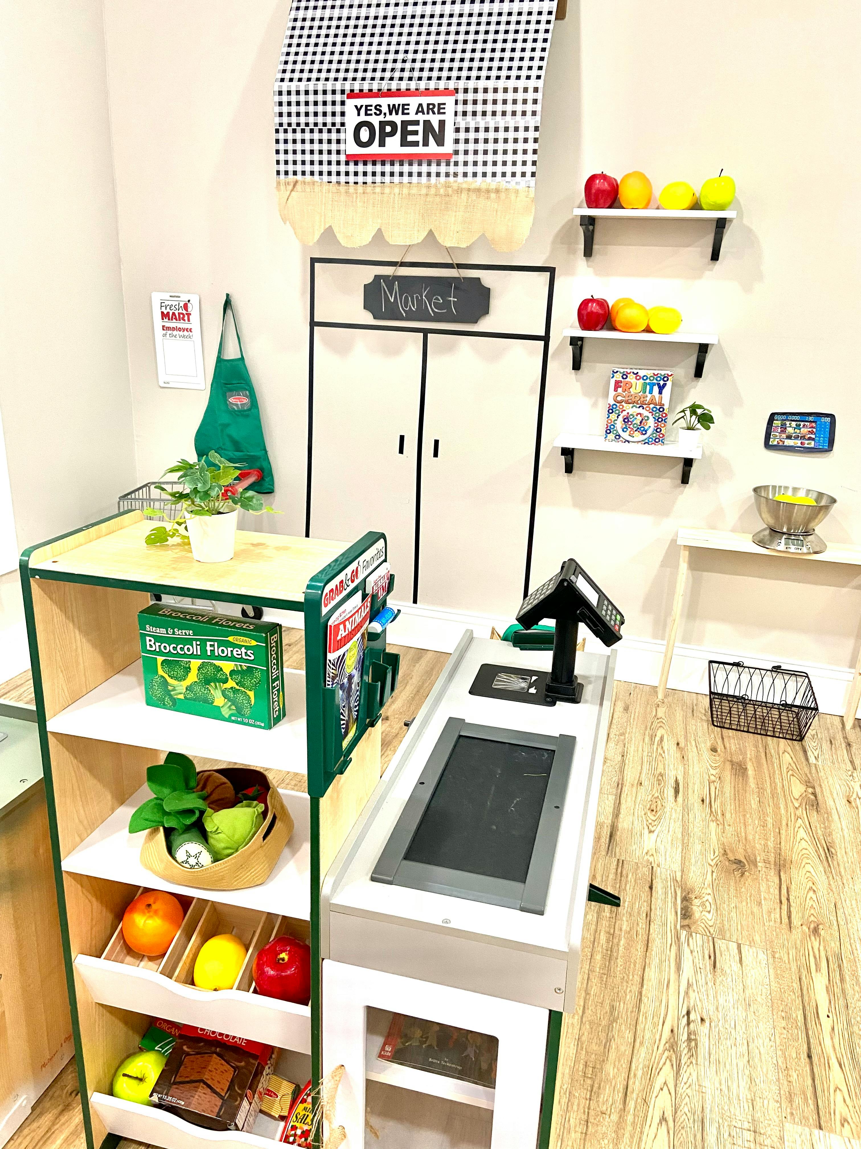 Play market with shelves of toy food and a checkout counter