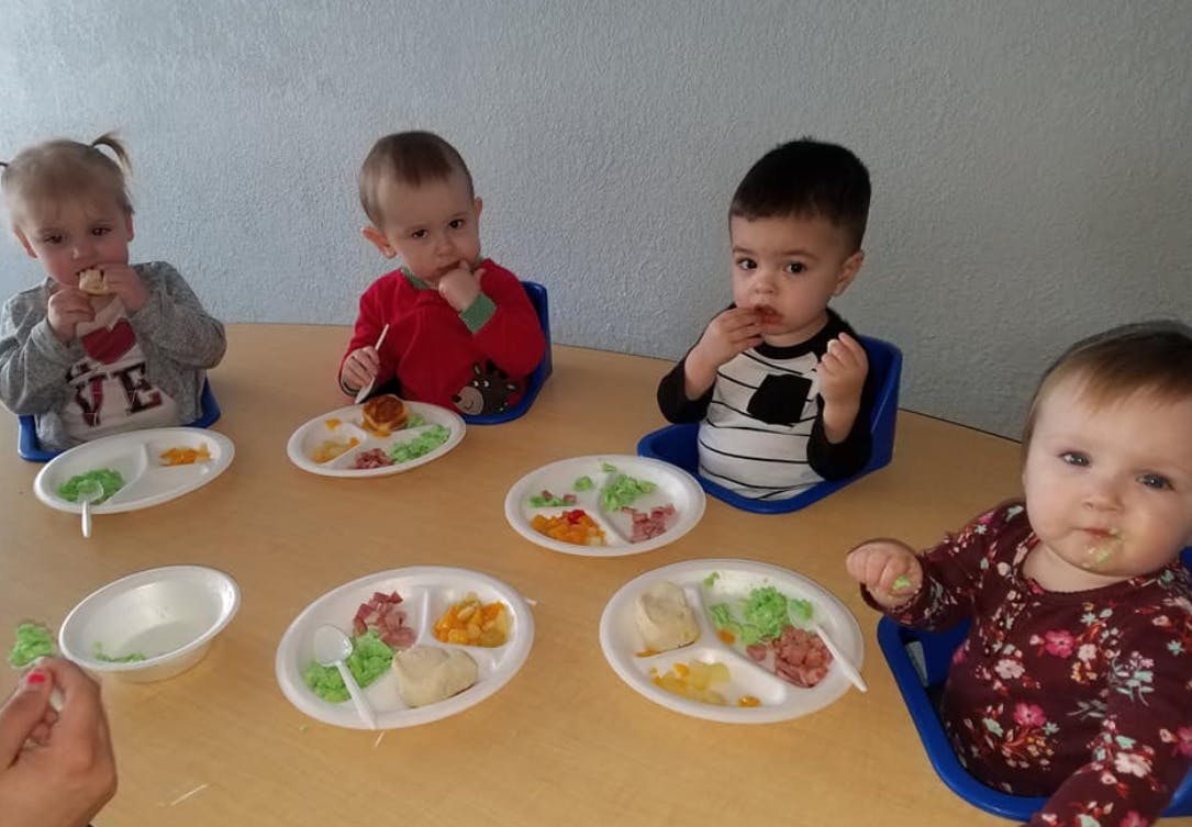Four children eating meals at a table