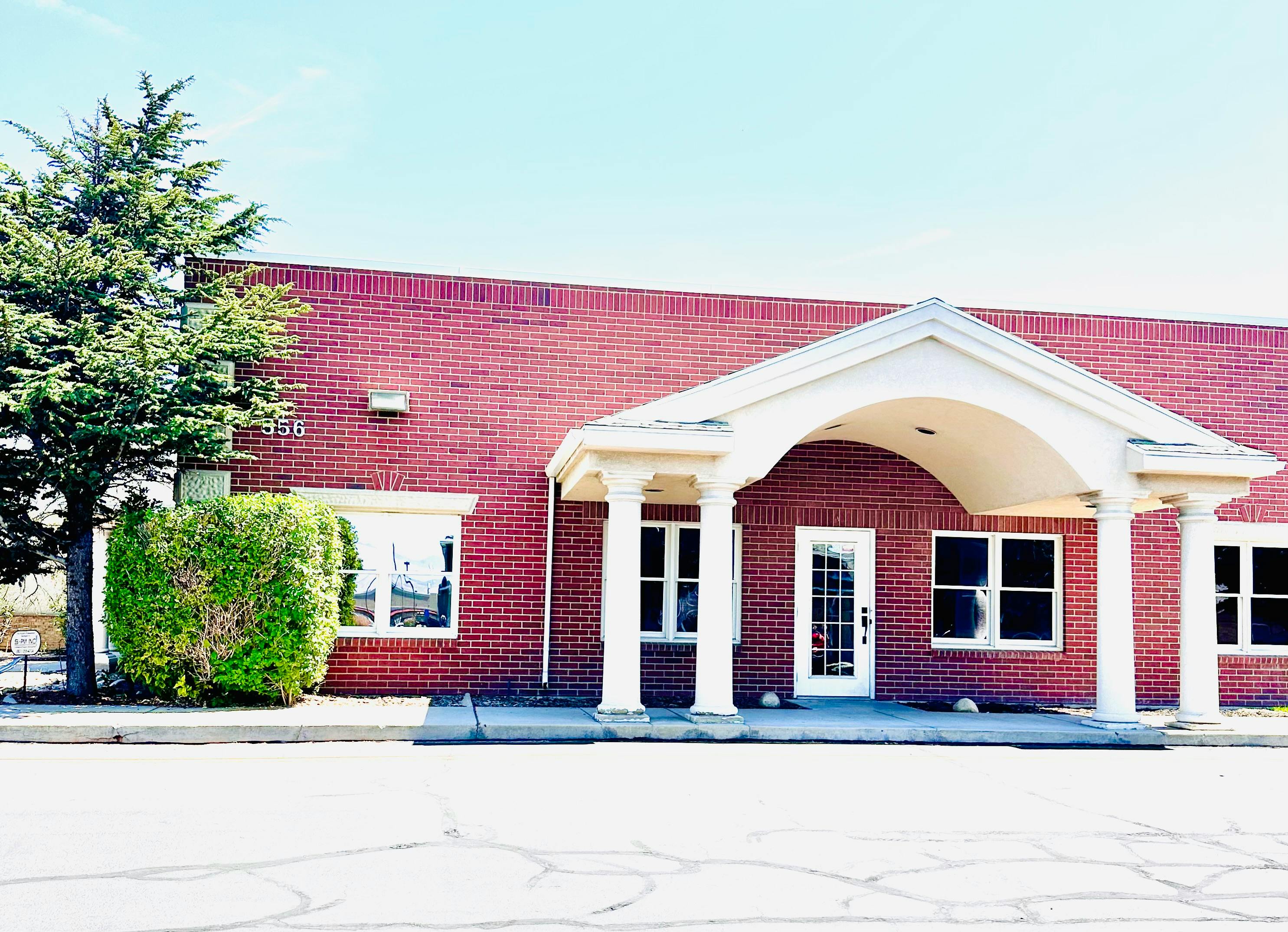 Red brick building with white portico and columns