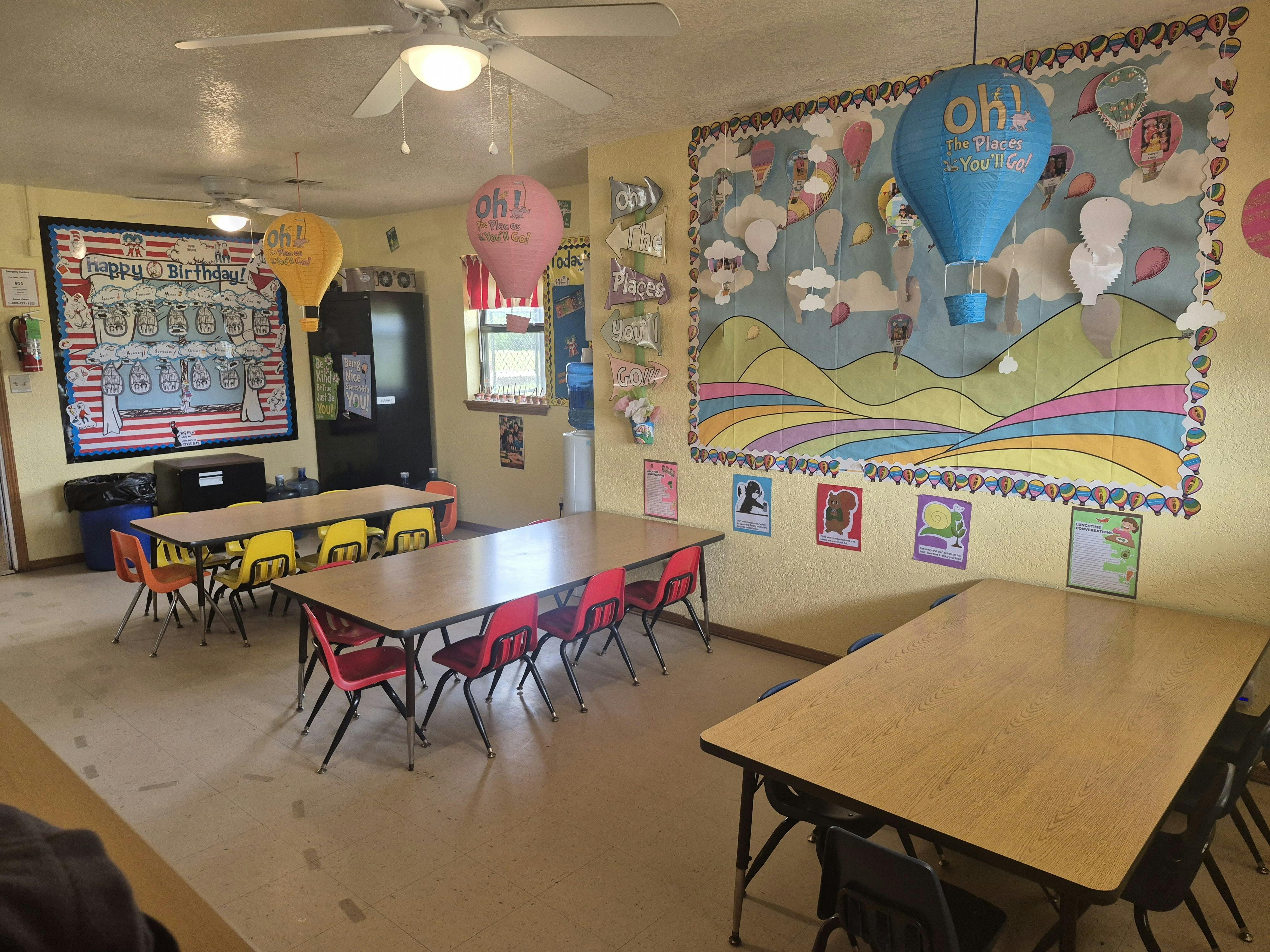 Classroom with multiple tables and chairs, decorated walls
