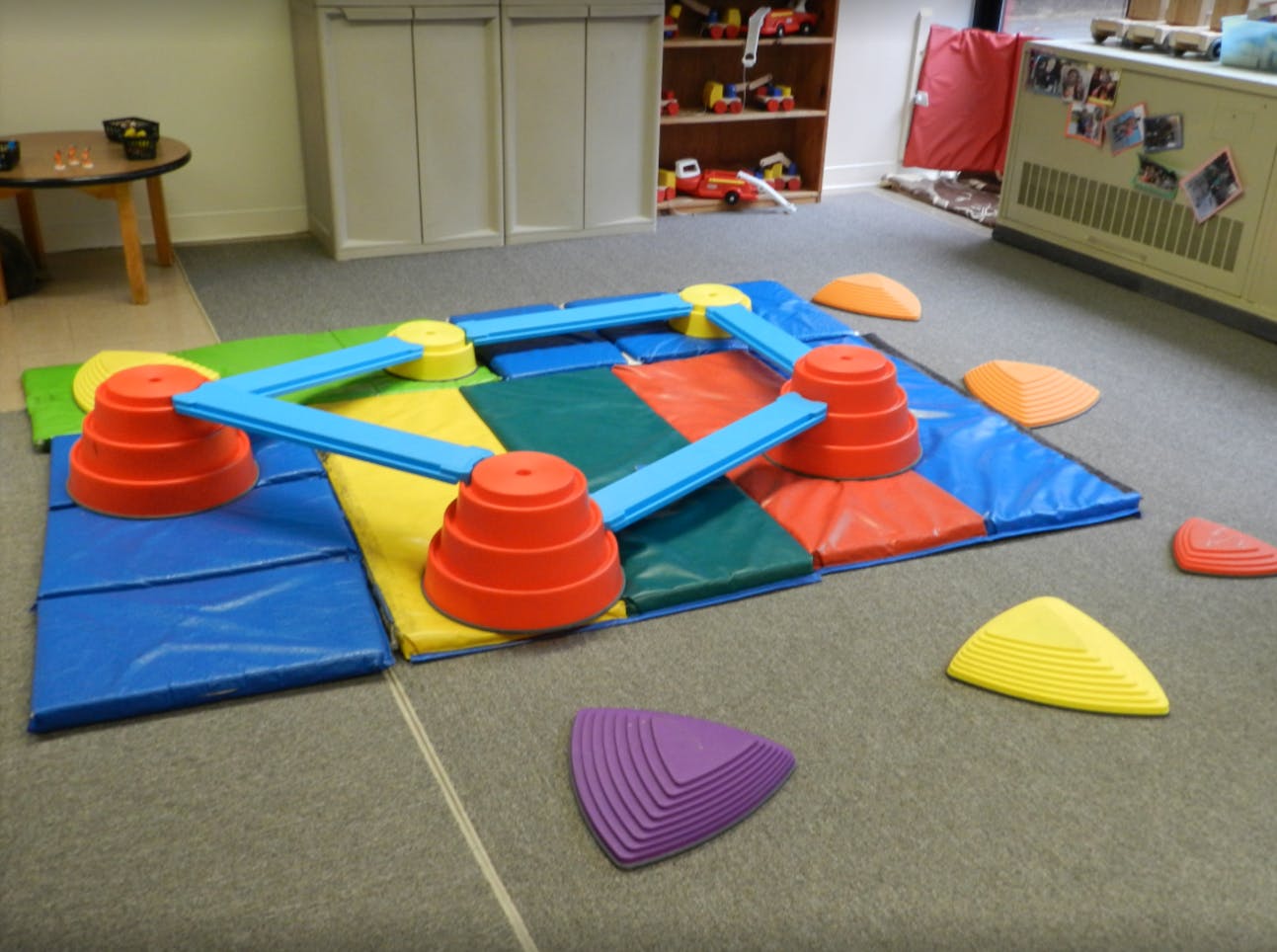 Children's play equipment with mats, cones, and balance beams