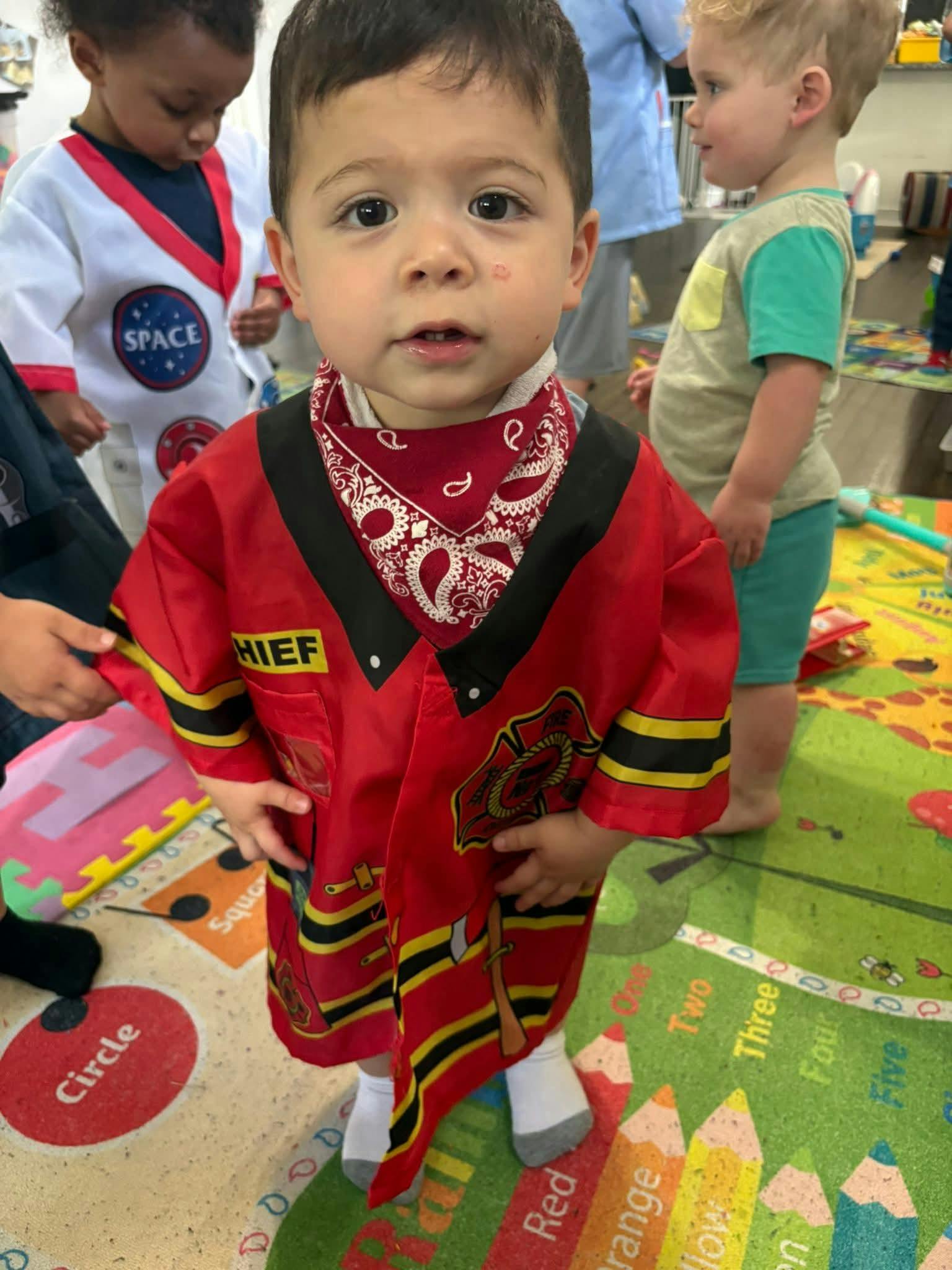 Child wearing a firefighter costume in a classroom