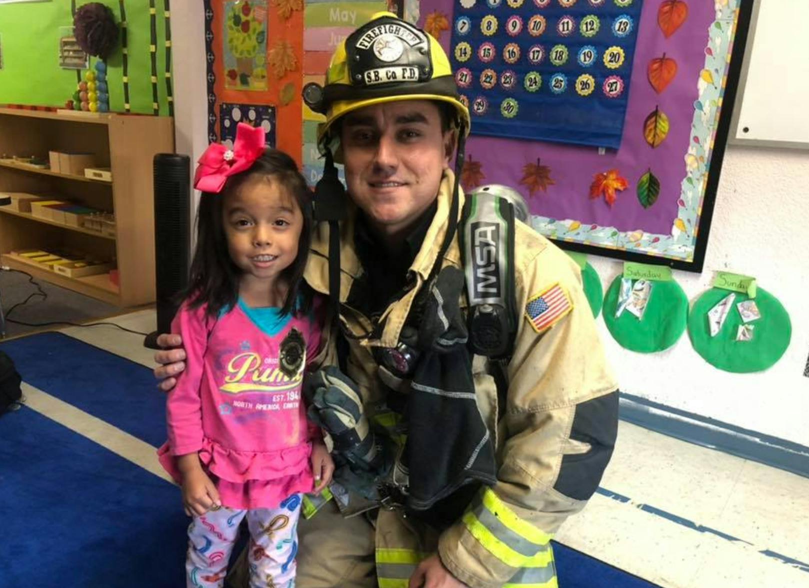 Firefighter in uniform with a child in a classroom