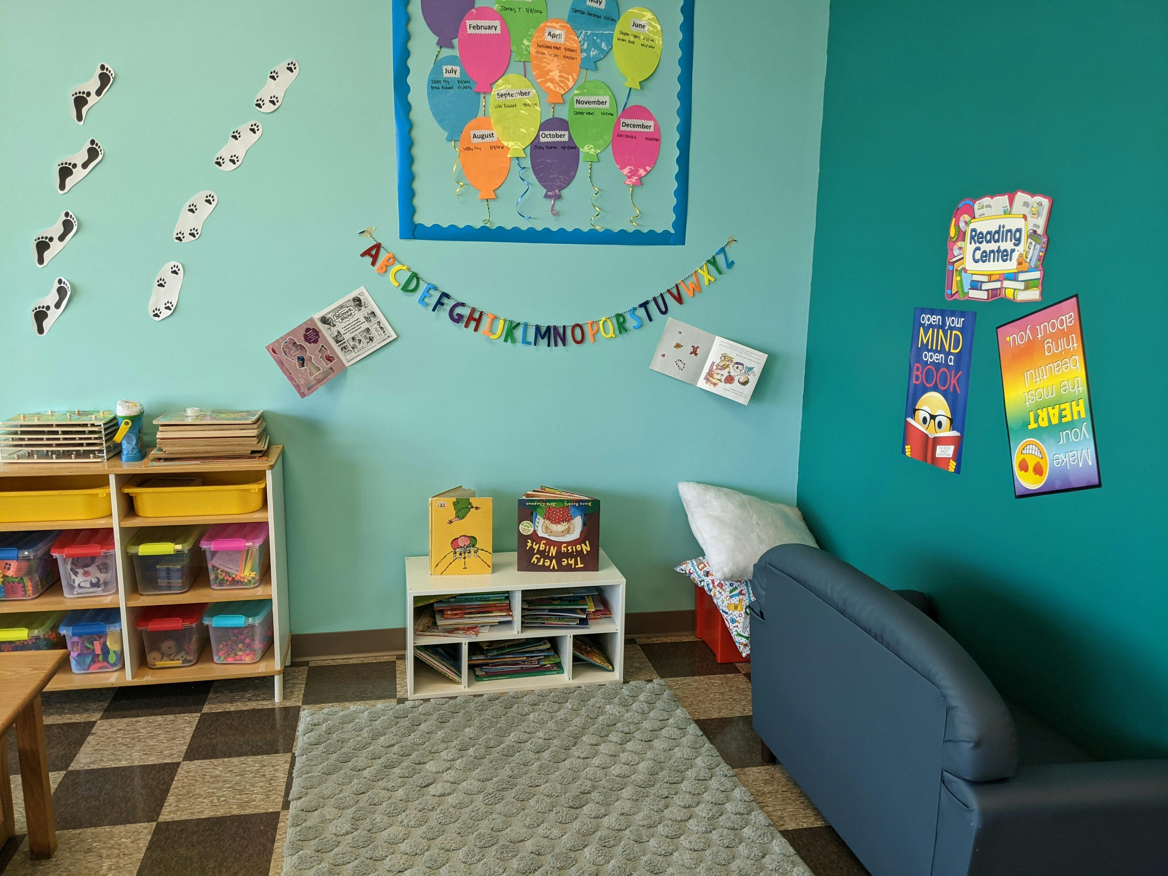 Classroom with colorful decorations, shelves, and a blue couch