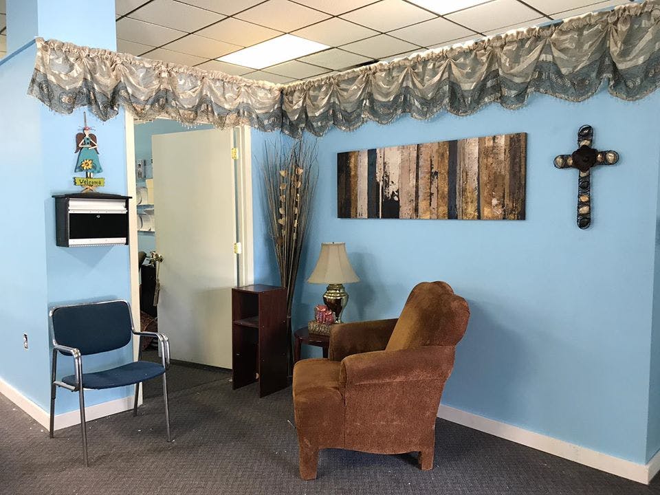 Waiting room with two chairs, a table, and wall decorations