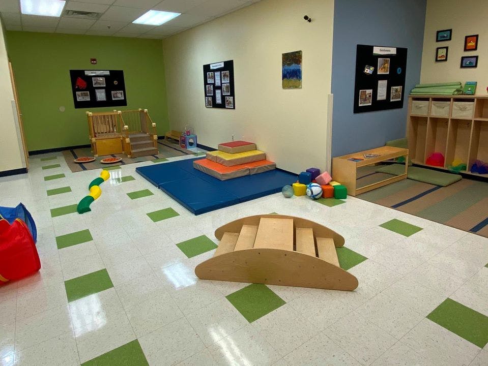 Playroom with mats, blocks, and wooden play equipment