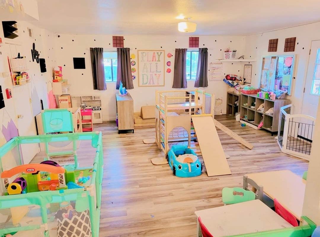 Playroom with cribs, play structures, and toys
